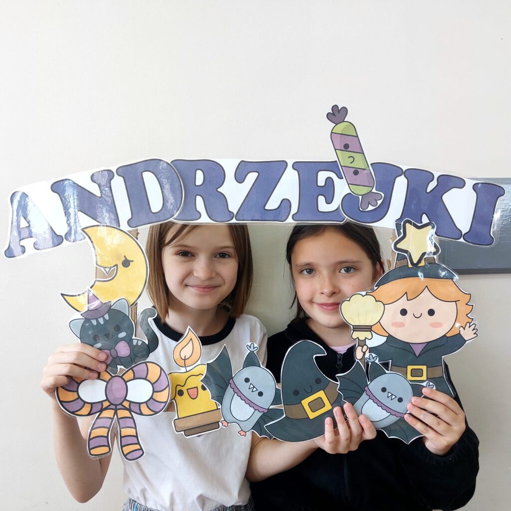 Dziewczynki trzymajace napis"Andrzejki"