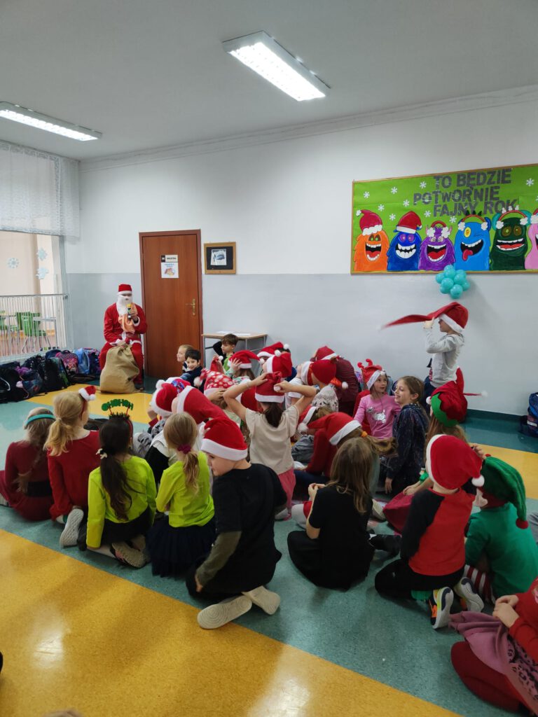 Dzieci w czapkach Mikołaja siedzą na korytarzu i słuchają Świętego Mikołaja!